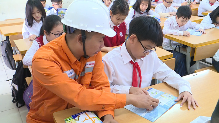 Le personnel d'EVNHANOI guide et répond aux questions des étudiants sur la consommation d'électricité.