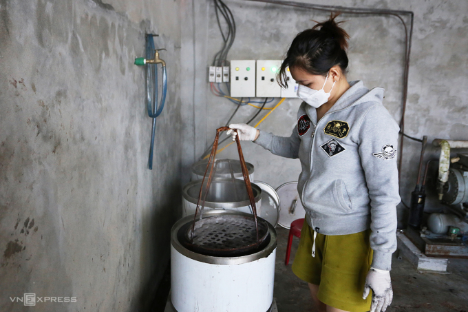 Ms. Truong Thi Ly boiled three pots of water to steam squid. Photo: Son Thuy