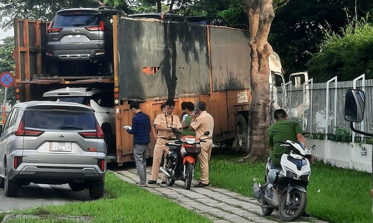 6台の車を積んだトラックが工場に衝突