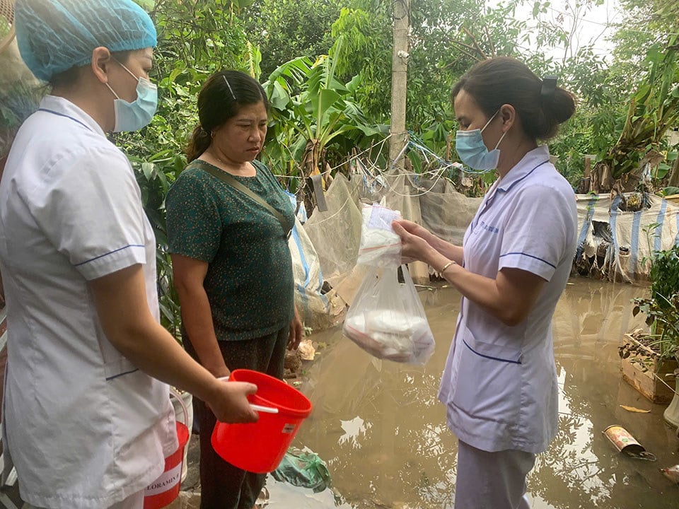 El personal médico del distrito de Bac Tu Liem (Hanoi) instruye a las personas sobre cómo manejar las fuentes de agua después de las inundaciones.