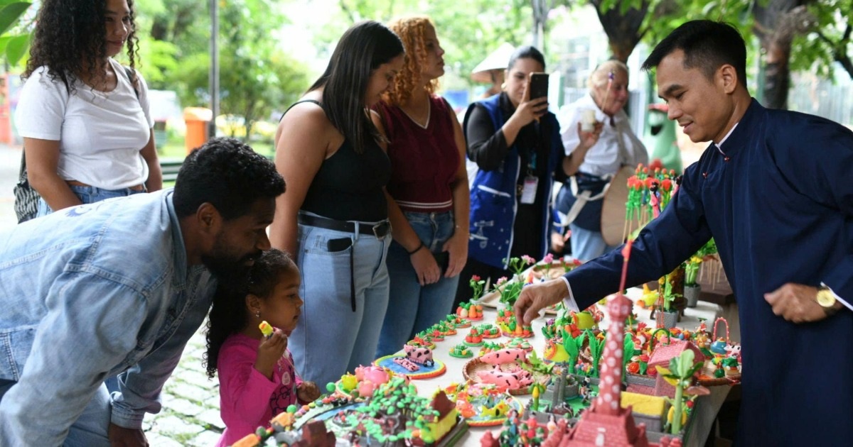 Brazilian people mold ball-shaped figurines and watch traditional Vietnamese martial arts.