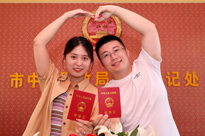 Una pareja se toma una foto después de recibir su certificado de matrimonio en Shandong, China, el 22 de agosto. Foto: AFP