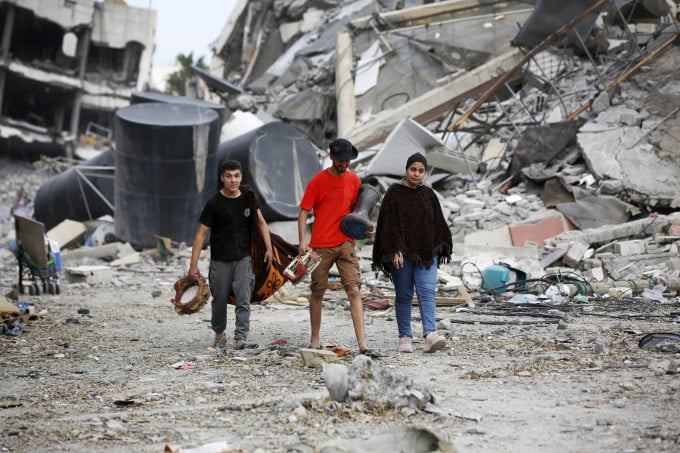 Palestinians carry what was left intact after Israeli bombardments in Gaza City, Gaza on November 25. Photo: AFP