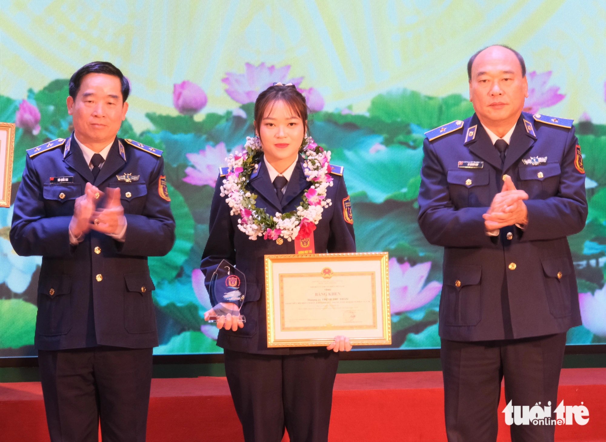 Trung tướng Bùi Quốc Oai - chính ủy Cảnh sát biển Việt Nam (trái) và thiếu tướng Lê Quang Đạo - tư lệnh Cảnh sát biển Việt Nam - trao bằng khen cho "bông hồng thép" Trịnh Thu Thảo - Ảnh: HÀ THANH