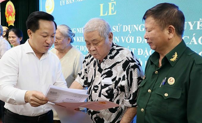 Chairman of Thu Duc City People's Committee Hoang Tung presents certificates to residents. Photo: Thanh Tuyen