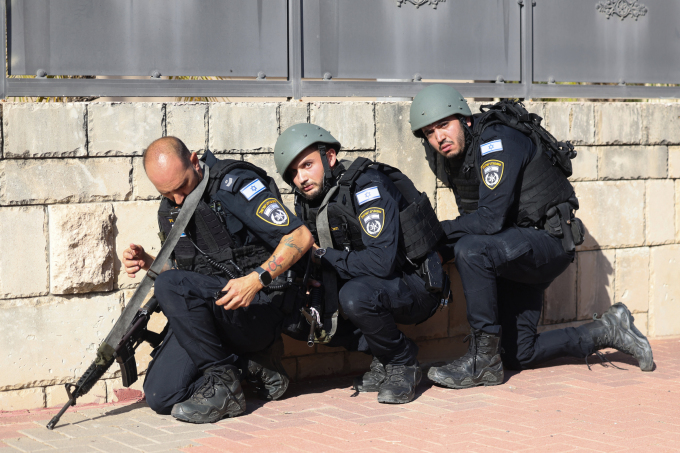 Quân nhân Israel ẩn nấp giữa đợt pháo kích của Hamas nhắm vào thành phố duyên hải Ashkelon ngày 7/10. Ảnh: AFP