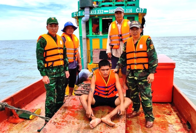 Song Doc Border Guard and fishermen brought the victim (sitting) to the mainland. Photo: Le Khoa