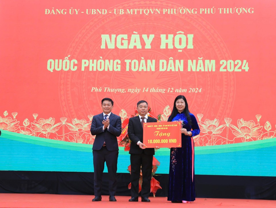 Chủ tịch Ủy ban Mặt trận Tổ quốc Việt Nam TP Hà Nội Nguyễn Lan Hương tặng hoa và trao quà chúc mừng của TP tới cán bộ, Nhân dân phường Phú Thượng 