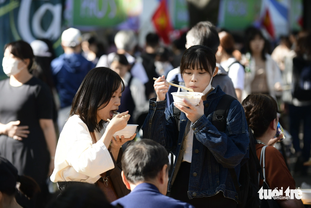 Japanese people enjoy slurping Vietnamese pho in the park