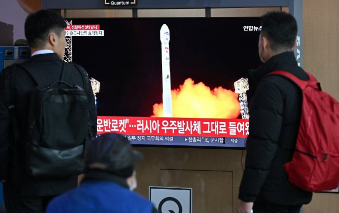 Los ciudadanos de Corea del Sur miran un informe de noticias sobre el lanzamiento del satélite de Corea del Norte en una estación de tren en Seúl el 22 de noviembre. Foto: AFP