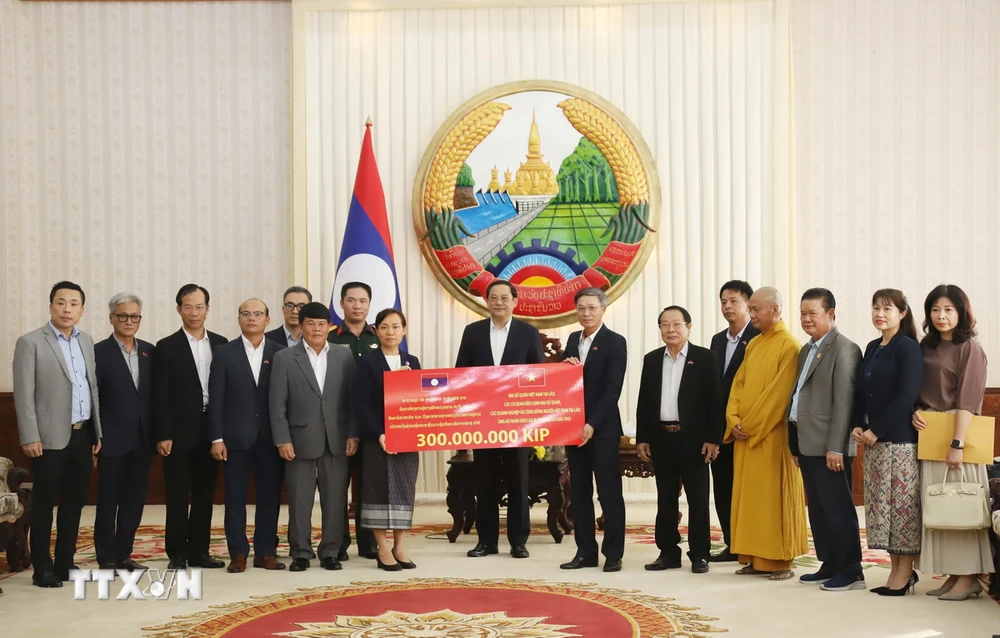 Des représentants de l'ambassade et de la communauté vietnamienne au Laos ont remis des dons et apporté leur soutien au Laos. (Photo : Xuan Tu/VNA)