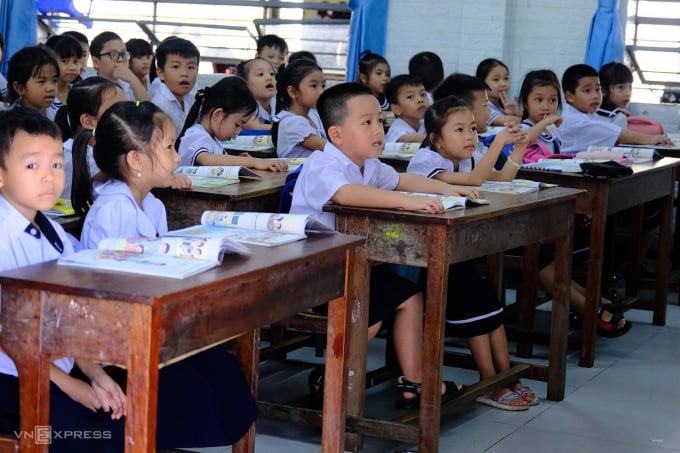 Học sinh lớp 1 ngồi bàn liền ghế, cùng kích cỡ như học sinh lớp 4. Ảnh: Nguyễn Đông