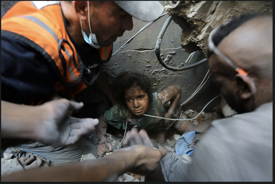Người Palestine cứu một cô gái ra khỏi đống đổ nát của tòa bị phá hủy bởi cuộc không kích của Israel ở trại tị nạn Jabaliya, phía bắc Dải Gaza. Ảnh: AP 