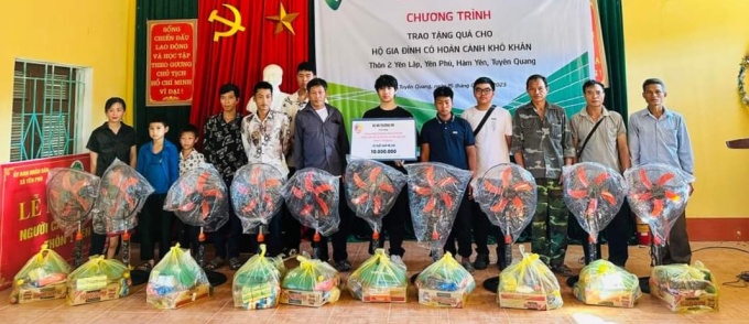 Minh (mit einem Schild) und Mitglieder des Thuong Em-Projekts überreichen armen Familien Geschenke und überholen Computer für benachteiligte Schulen in Tuyen Quang, Juli 2023. Foto von : Character provided