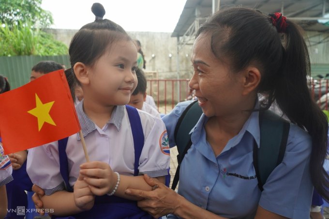 นางสาวคิม อวนห์ พาลูกสาวไปที่โรงเรียนประถมศึกษาเหงียนไทฮอค เมืองเบียนหว่า จังหวัดด่งนาย เพื่อเข้าร่วมพิธีเปิด ภาพ : เฟื้อกตวน