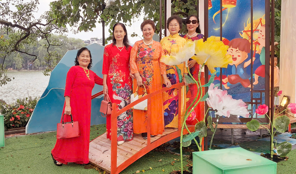 Des touristes prennent des photos avec les lanternes de la fête de la mi-automne lors du festival d'automne de Hanoi 2024. Photo : Hoai Nam