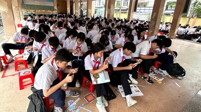 Les élèves découvrent avec enthousiasme le découpage et le collage du modèle de la tour du drapeau de Hanoi