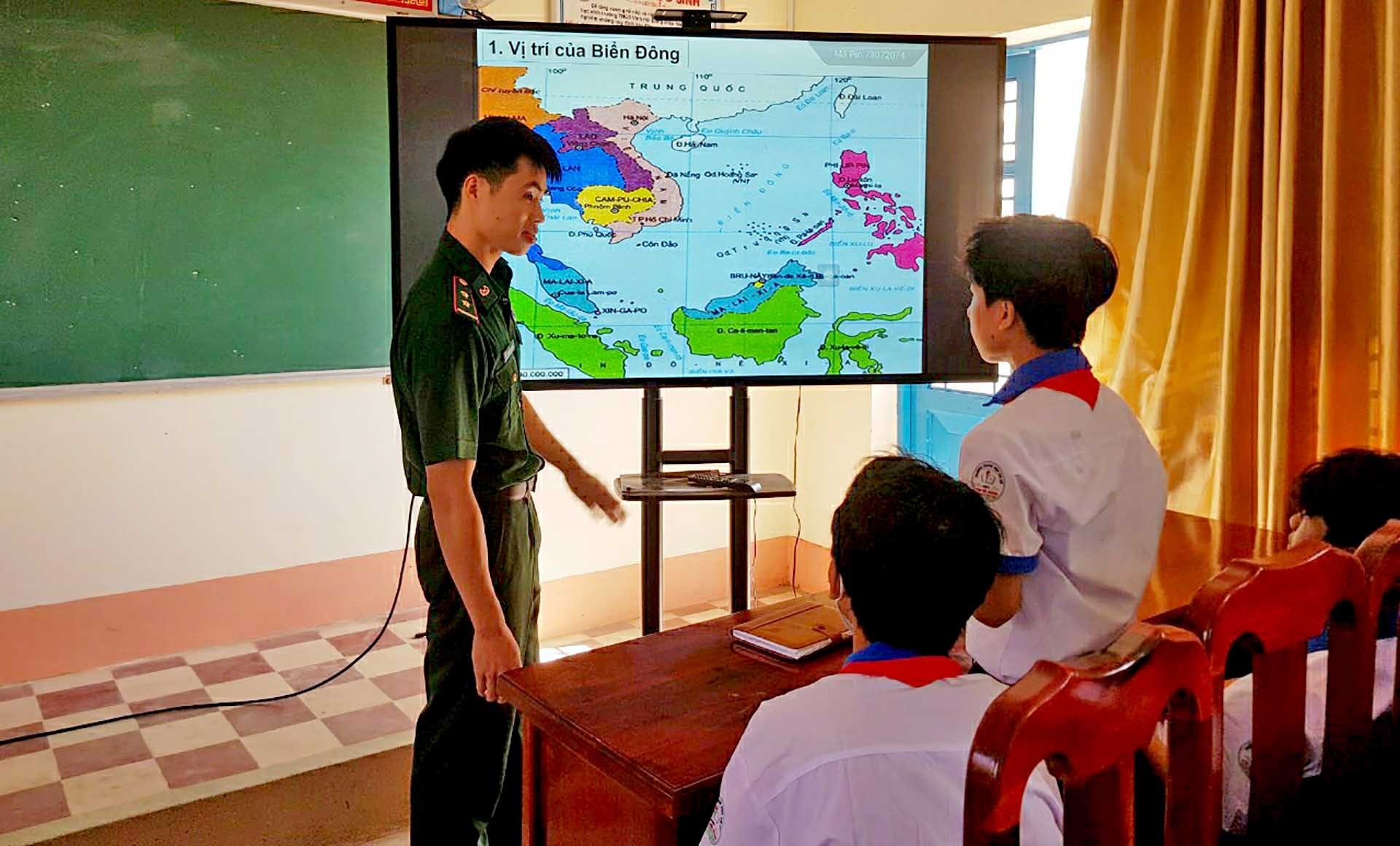 Cán bộ Đồn Biên phòng cửa khẩu Vĩnh Hội Đông trực tiếp tuyên truyền về chủ quyền biên giới, biển đảo cho giáo viên, học sinh Trường THCS Vĩnh Hội Đông. (Ảnh: Chiến Khu)