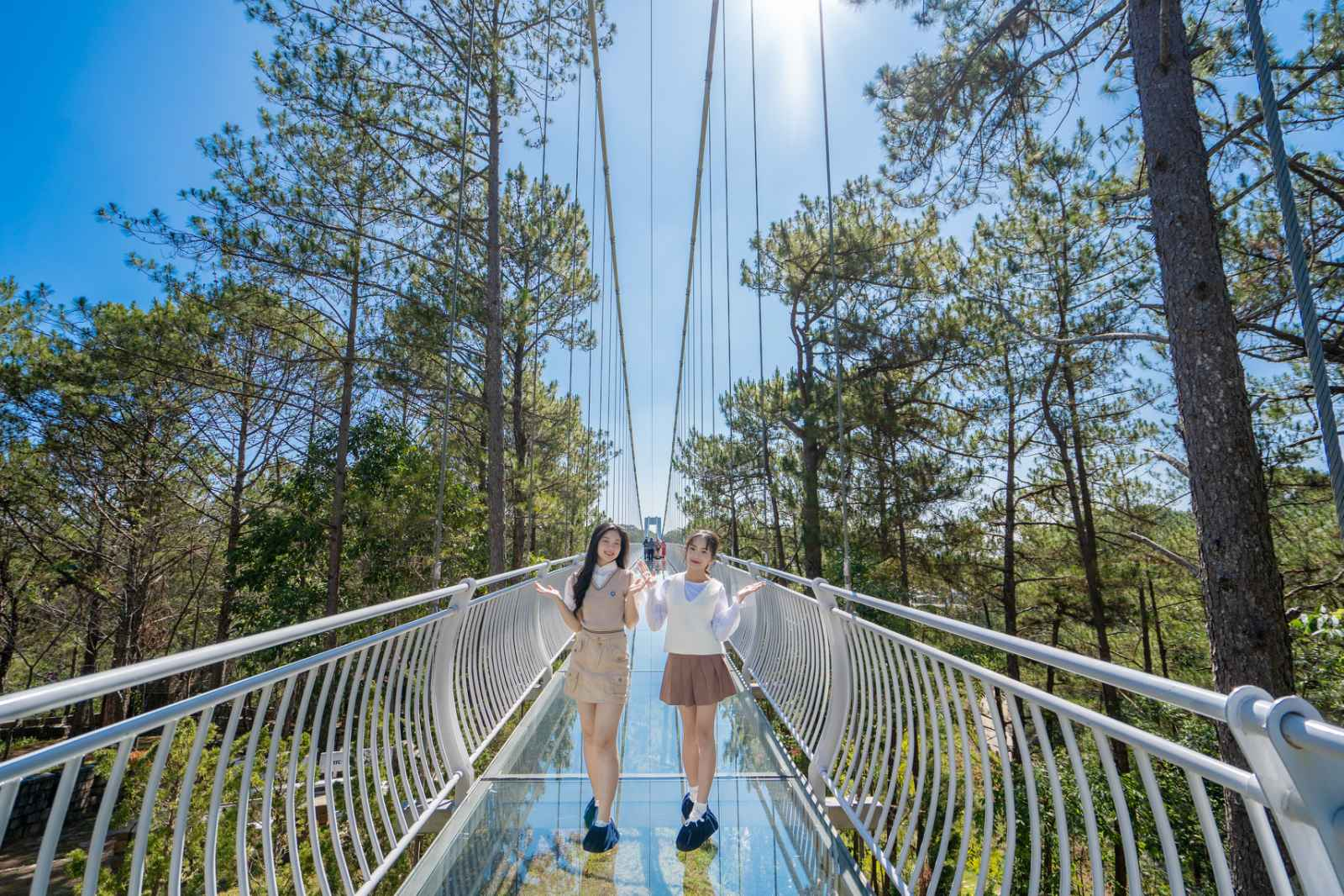 Two women standing on a bridge  Description automatically generated