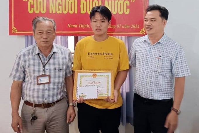 Viet (en el centro) recibió un certificado de mérito del Comité Popular de la comuna de Hanh Thinh por su acción al salvar a una persona que se estaba ahogando, el 10 de enero. Foto: Nghia Hanh