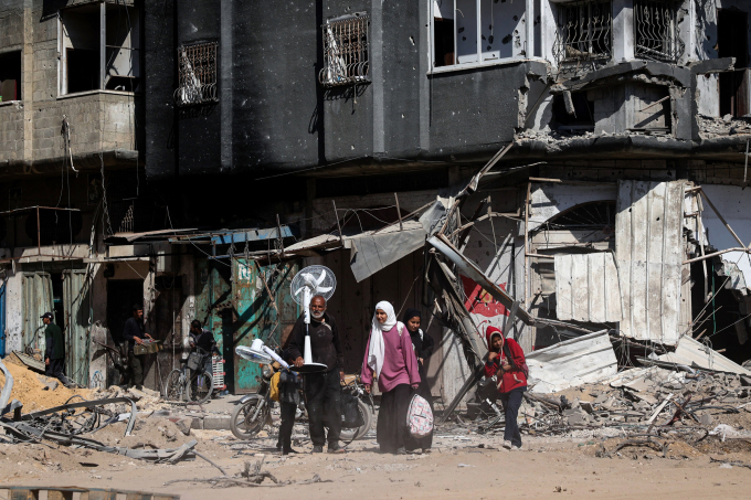 4月7日、ガザ地区のハンユニスで戦闘の瓦礫の中から避難するパレスチナ人たち。写真：AFP