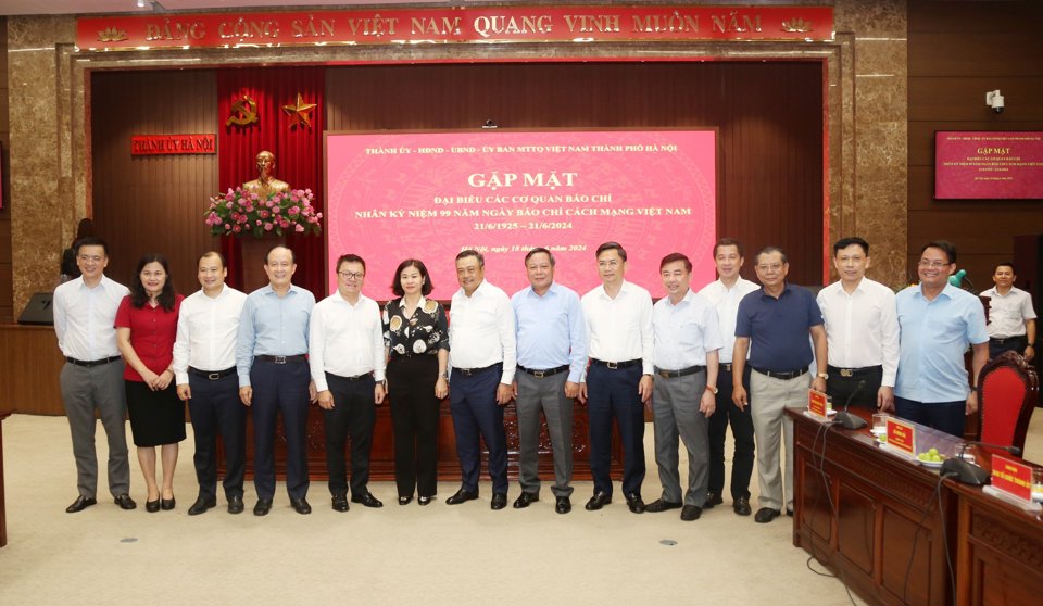 Hanoi leaders with representatives of central and Hanoi press agencies at the meeting on June 18. Photo: Pham Hung