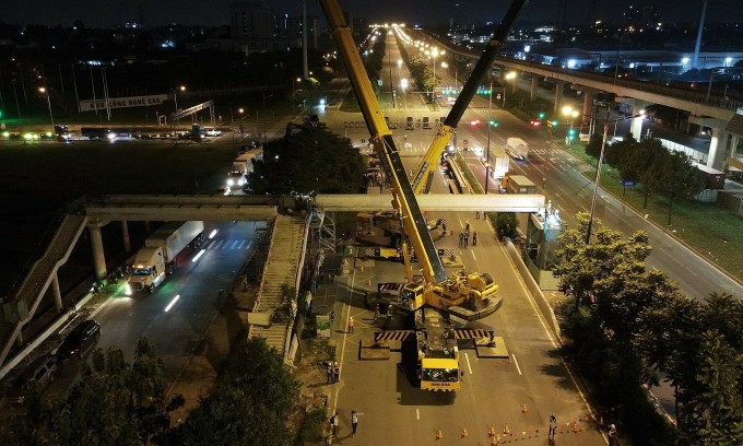 Une partie de l'autoroute de Hanoi est fermée pour permettre aux entrepreneurs d'installer des poutres reliant la station High-Tech Park sur le côté droit de l'image. Photo : Ha Giang