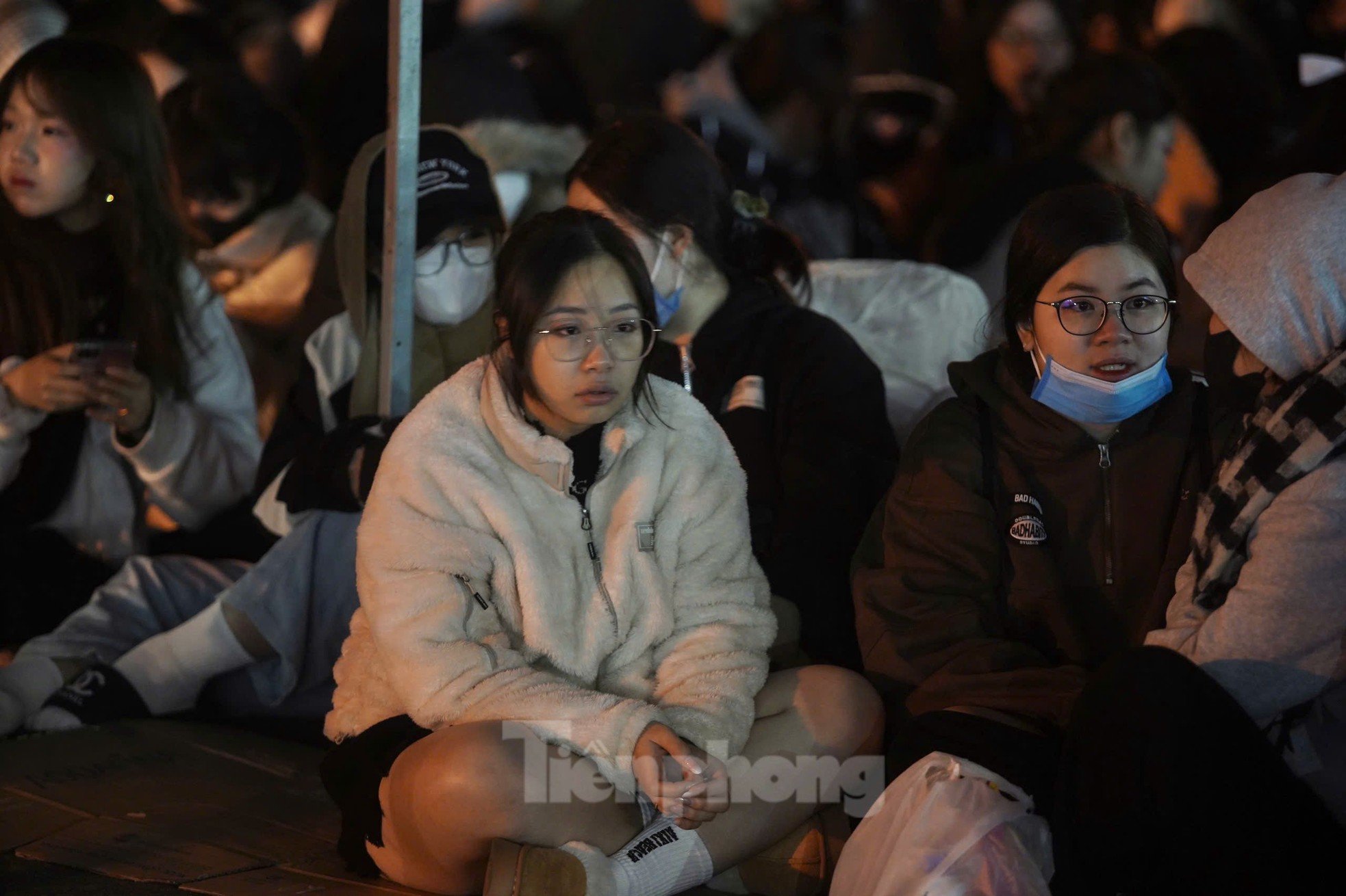 Long lines of spectators covered in scarves, sitting and sleeping right in front of My Dinh Stadium photo 2