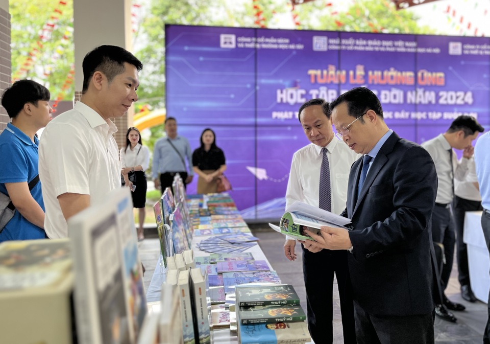 El director del Departamento de Educación y Capacitación de Hanoi, Tran The Cuong, visita el área de exposición de libros.