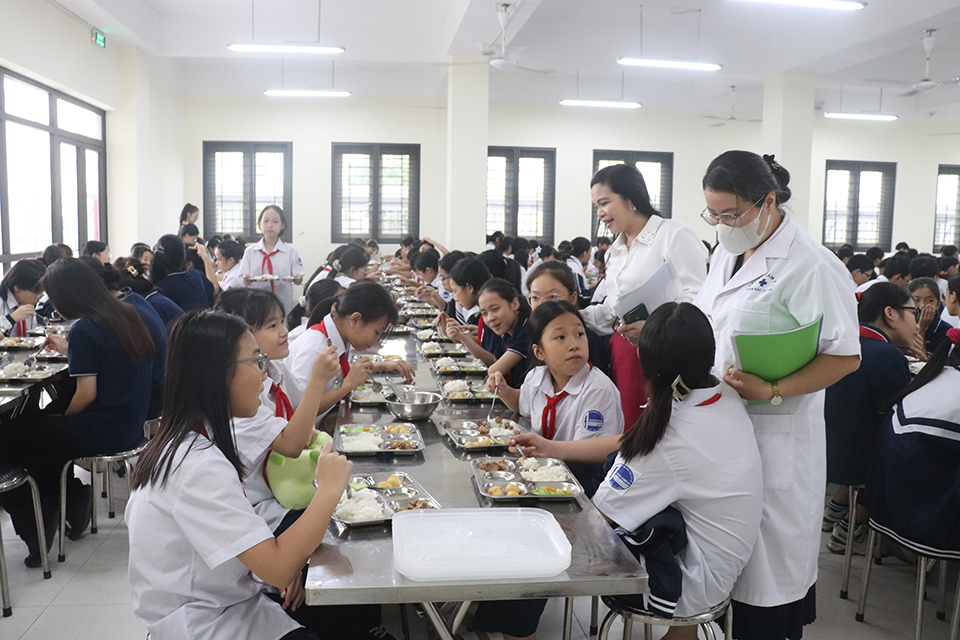 Lehrerin Hoang Thi To Oanh – stellvertretende Schulleiterin der Nguyen Thi Minh Khai Secondary School – und medizinisches Personal besuchten die Schüler und sprachen während ihres Mittagessens mit ihnen.