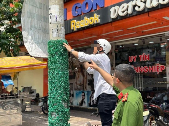 Dán quảng cáo rao vặt, chủ nhà trọ bị công an đưa đi bóc xóa - Ảnh 1.
