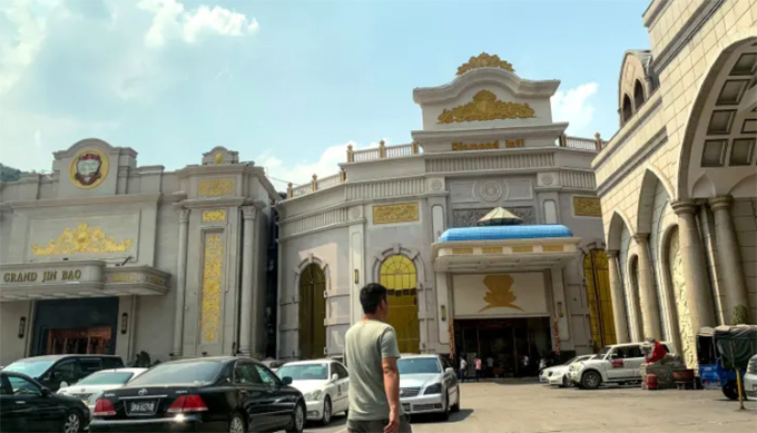 Un hombre se encuentra cerca de un casino a lo largo de la frontera entre Myanmar y China, conocida como un foco de tráfico de personas, drogas y vida silvestre. Foto: AFP