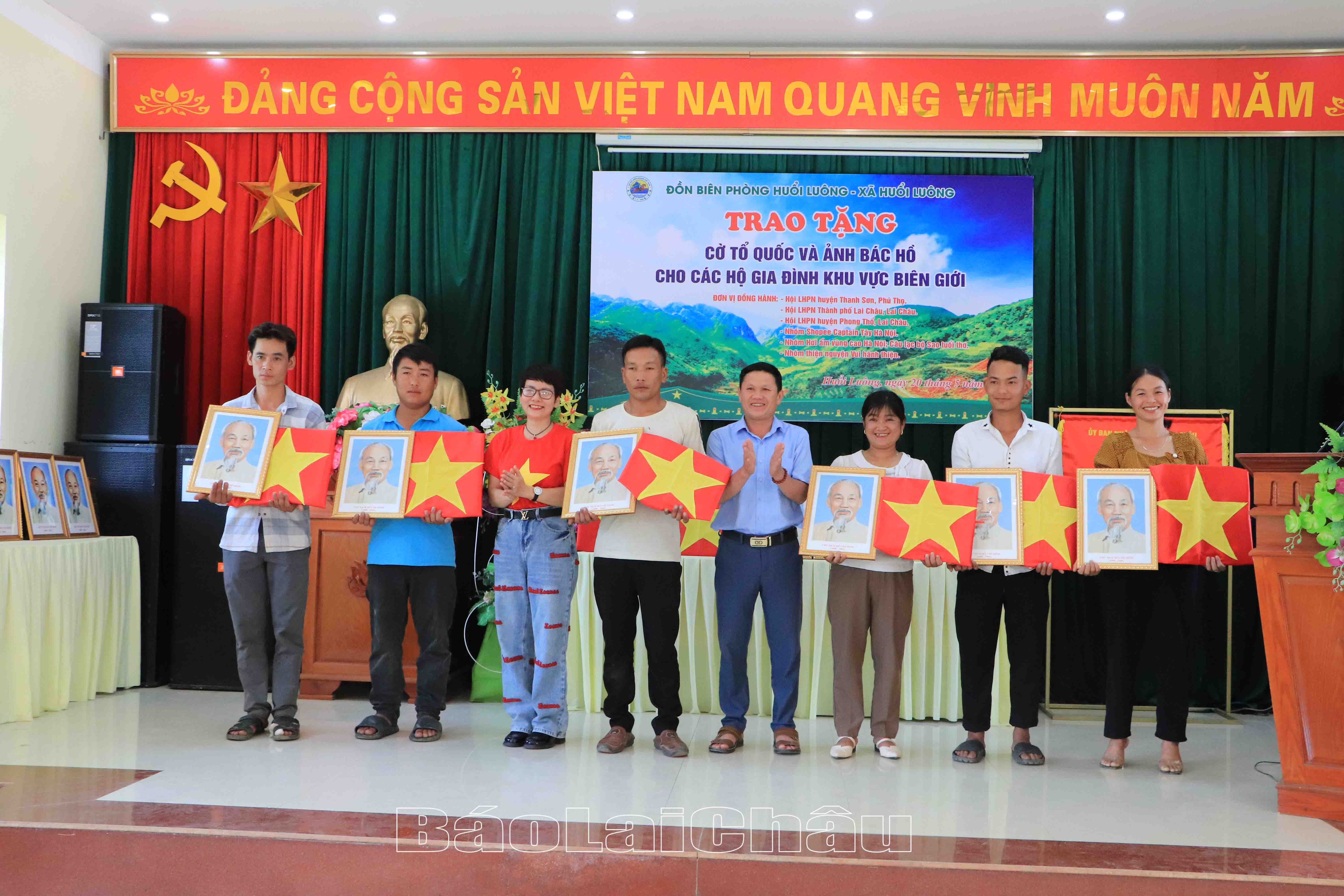 Đại diện lãnh đạo xã Huổi Luông, Nhóm thiện nguyện hơi ấm vùng cao Hà Nội trao cờ tổ Quốc và ảnh Bác Hồ cho Nhân dân các bản. 