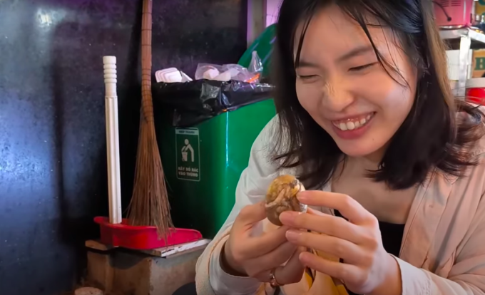 Eine japanische Touristin schält alleine ein Balut-Ei. Aus Clip ausgeschnittenes Foto