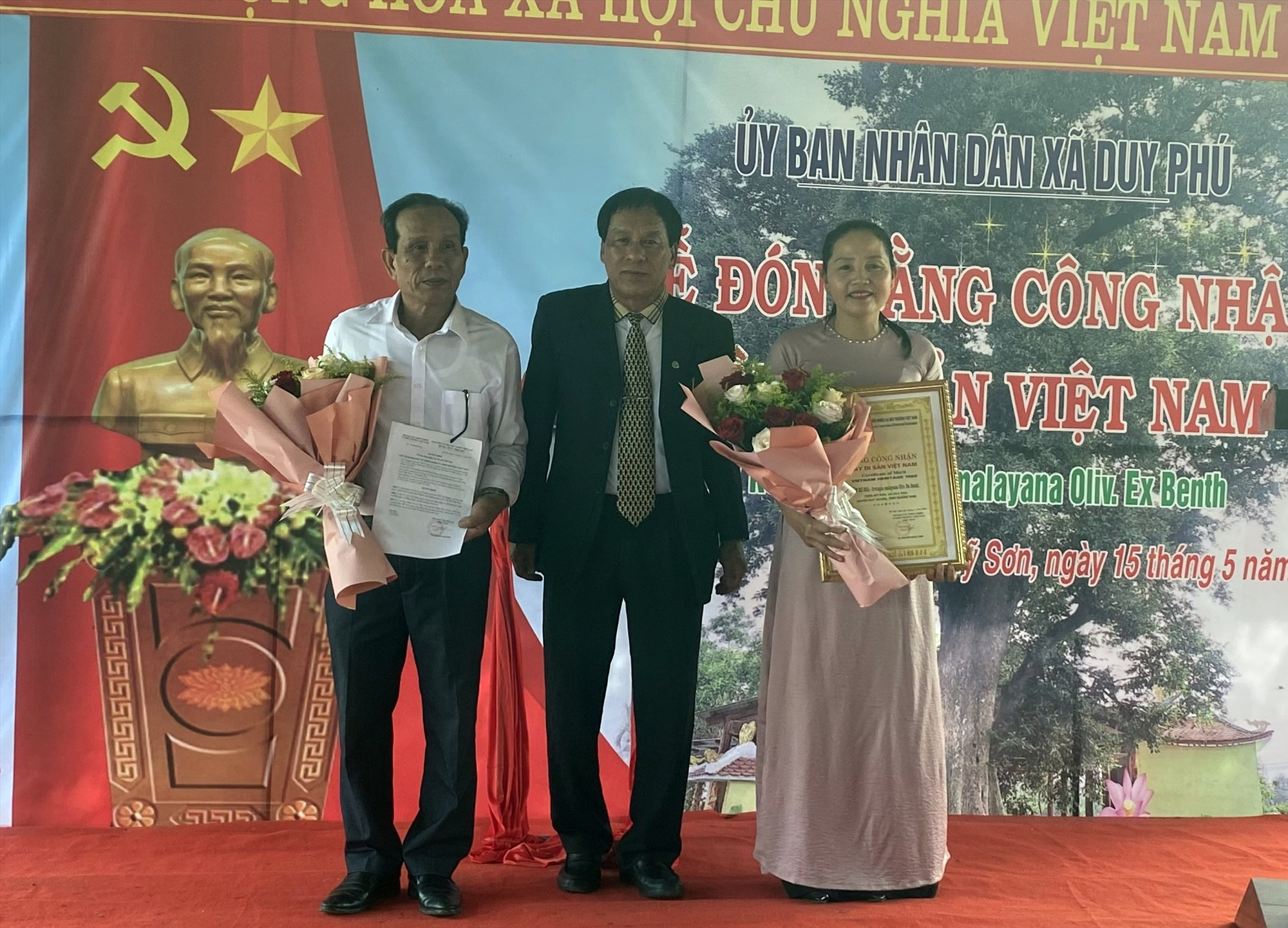 Đại diện Hội Bảo vệ thiên nhiên và môi trường Việt Nam trao Bảng công nhận Cây di sản Việt Nam cho lãnh đạo xã Duy Phú. Ảnh: K.L