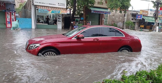 Автомобили были глубоко затоплены на улице Донг Хой после сильного дождя днем ​​22 мая. Фото: Тай Ха