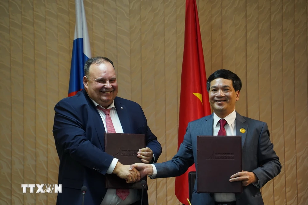 Firma del acuerdo de adhesión a la Asociación entre representantes de la FU y la Universidad de Economía de la Universidad Nacional de Vietnam, Hanói. (Foto: Duy Trinh/Corresponsal de VNA en Rusia)