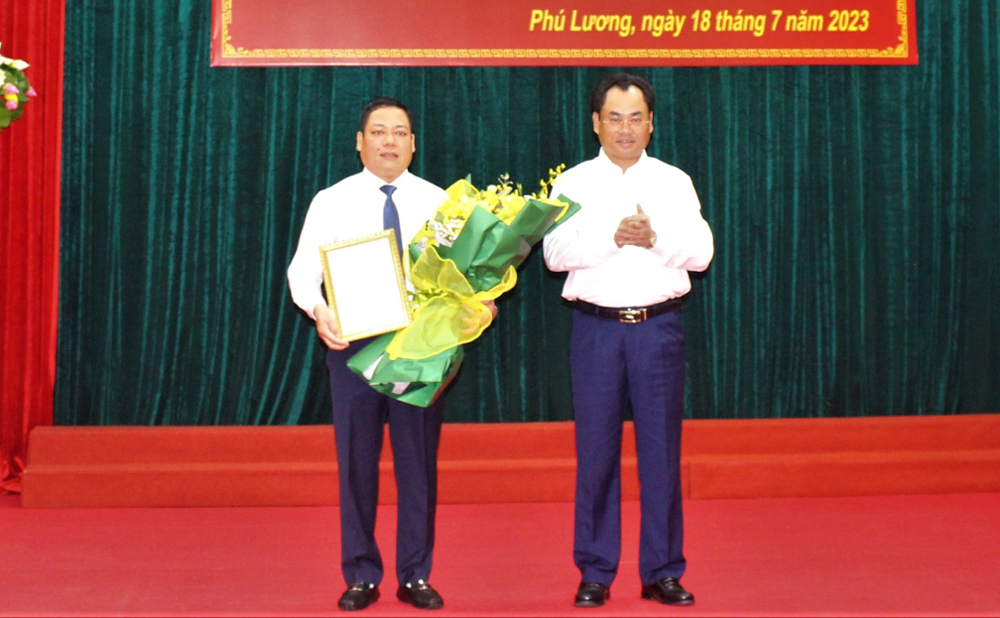 Đồng chí Chủ tịch UBND tỉnh Trịnh Việt Hùng trao quyết định và tặng hoa chúc mừng đồng chí Nguyễn Hoàng Mác.