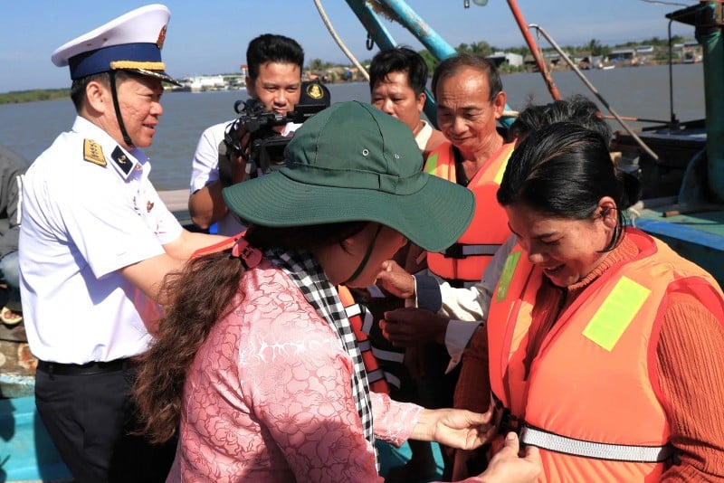 Lãnh đạo các đơn vị trao áo phao cho bà con ngư dân.