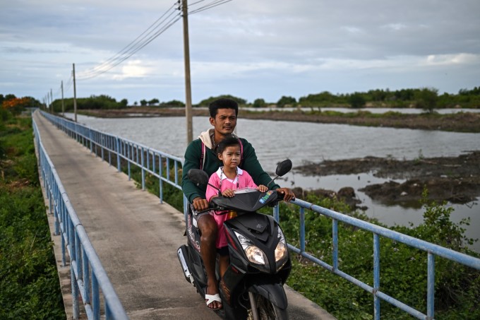 Un padre llevó a su hija a una escuela fuera del pueblo. Foto: AFP