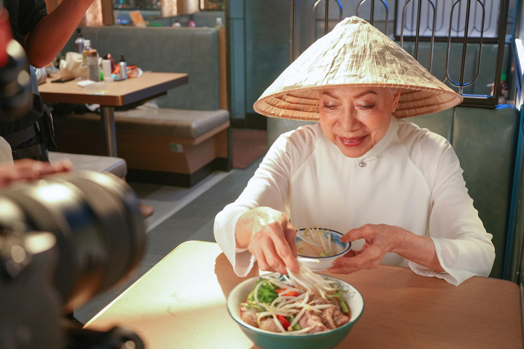 La estrella de 'Condor Hero' usa ao dai y sombrero cónico para comer pho