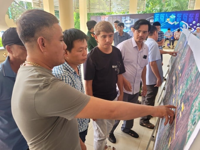 Les habitants du district de Long Thanh discutent de la direction de l'autoroute Bien Hoa - Vung Tau lorsqu'elle traverse leur territoire. Photo : Phuoc Tuan