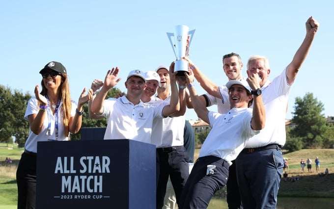 Djokovic (Mitte), Bale (dritter von rechts) und Mitglieder von Team Monty heben den Pokal für das Gewinnerteam des All-Star-Matches hoch. Foto: Ryder Cup