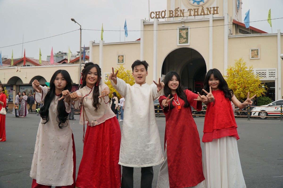 Des jeunes portant l'ao dai pour l'enregistrement du Têt au marché de Ben Thanh