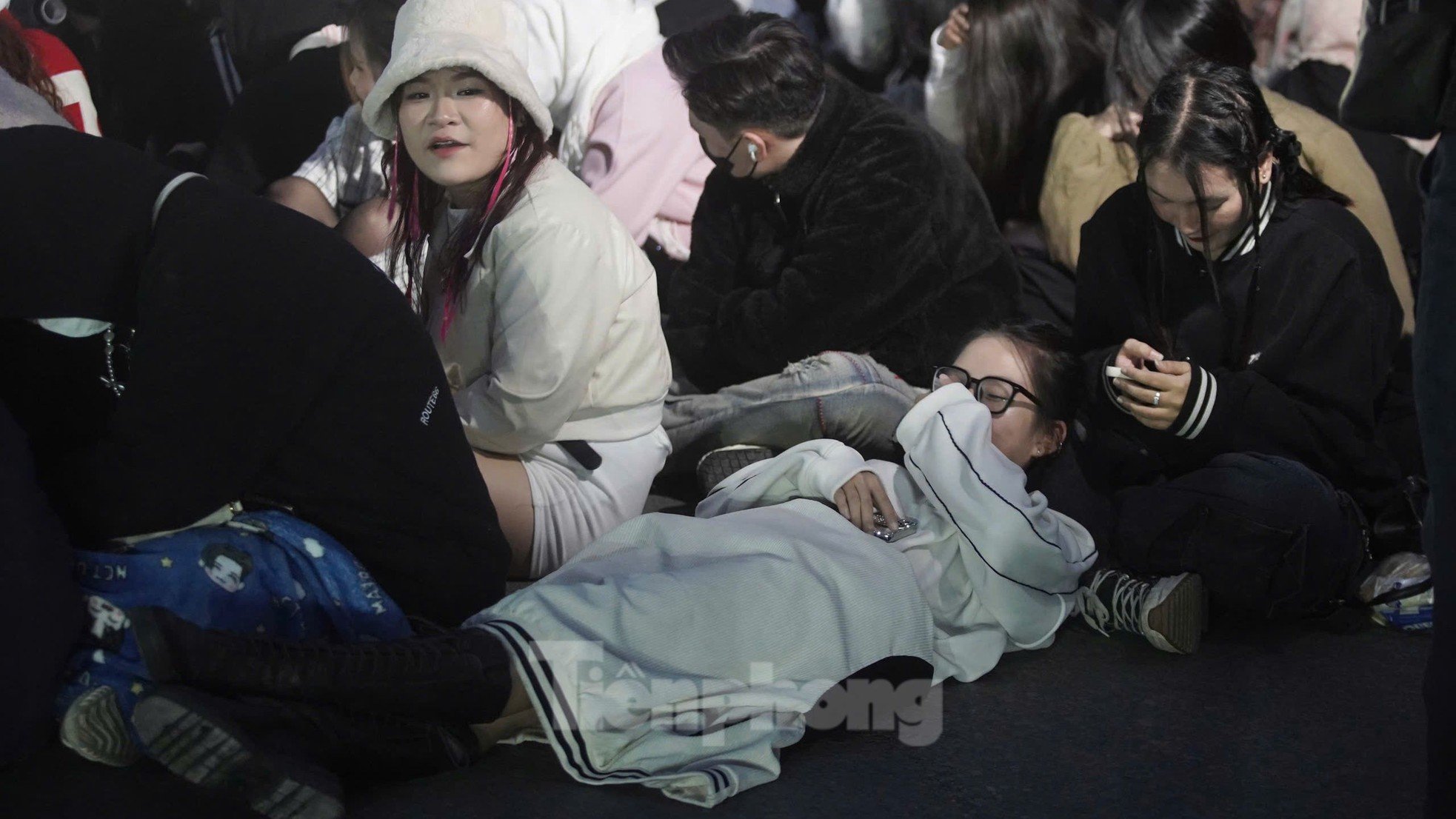 Long lines of spectators covered in scarves, sitting and sleeping right in front of My Dinh Stadium photo 11