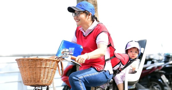 Female principal in Hanoi cycles around West Lake with 1-year-old child for a very touching reason