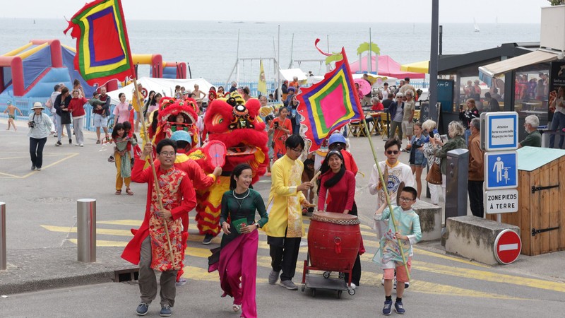 Niños y una procesión desfilan por las calles de la ciudad costera de Larmor-Plage.