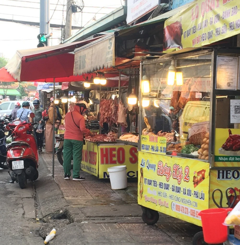 Pedestrians parked their vehicles on the street to buy pork at Hiep Binh spontaneous market, Thu Duc City, Ho Chi Minh City.