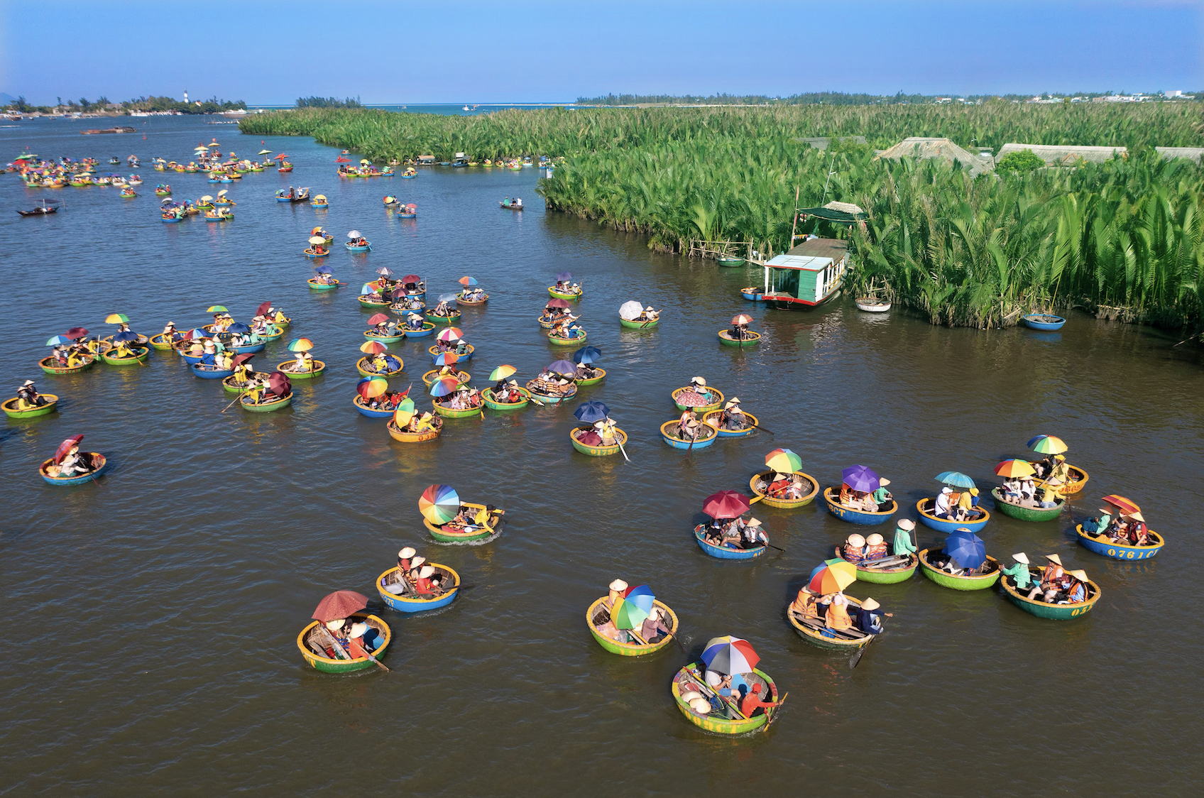 On the wharf and under the boat, there are many tourists in the Bay Mau coconut forest in Hoi An.