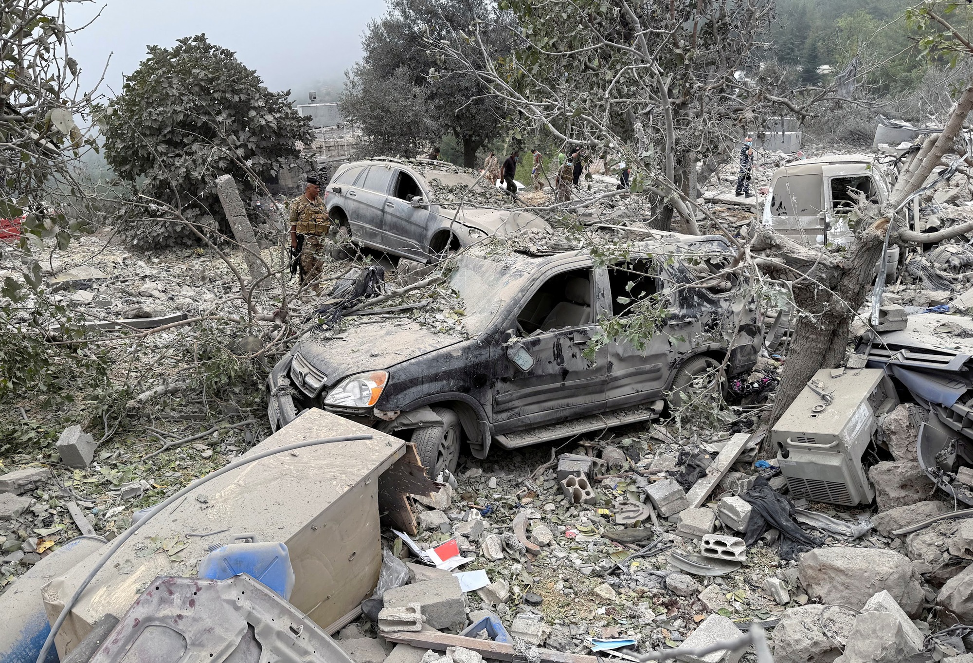 Lebanese army soldier stands at a site damaged by an Israeli air strike in Aitou